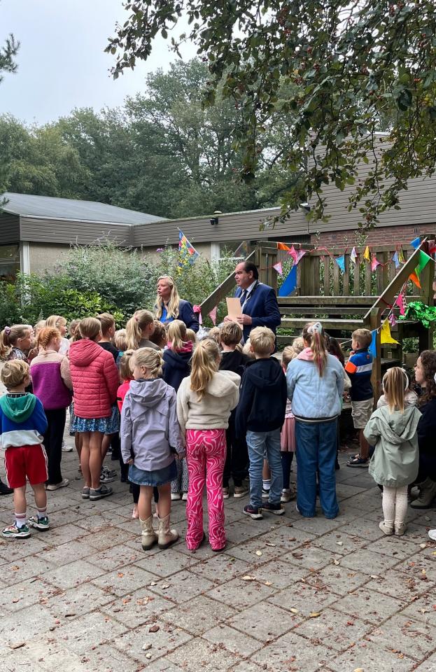 De burgemeester spreekt met een groep kinderen 