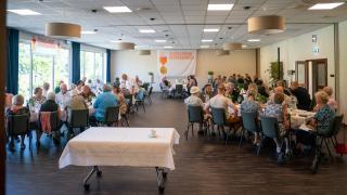 Overzichtsfoto: 9 tafels gevuld met mensen in Hotel Zeegser Duinen.