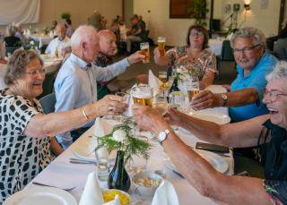 7 mensen proosten met elkaar aan tafel